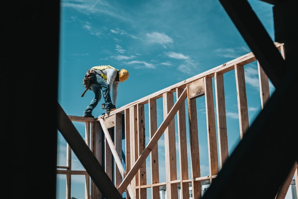 A residential construction crew framing an addition to an existing single-family home.